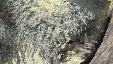 water flowing beneath a wall at a steady pace