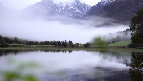 hermoso lago con el reflejo de enormes montañas nevadas en el fondo