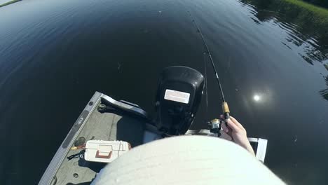 pov of man fishing with a fishing rod from a boat