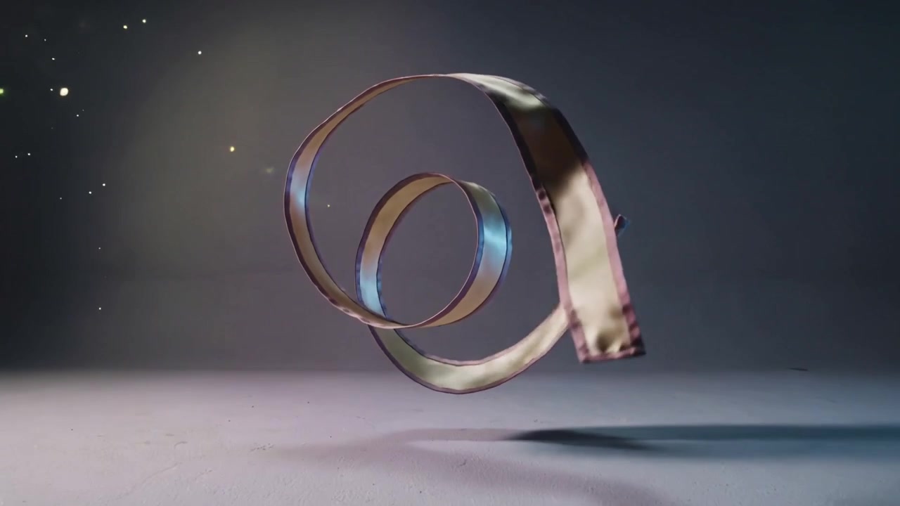 Von links eintretendes, gleitendes lila-goldenes Band bildet eine Spirale auf texturierter Bühne, Scheinwerferlicht funkelt.