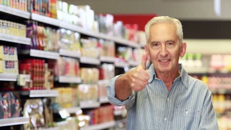 senior man showing thumbs up at grocery store