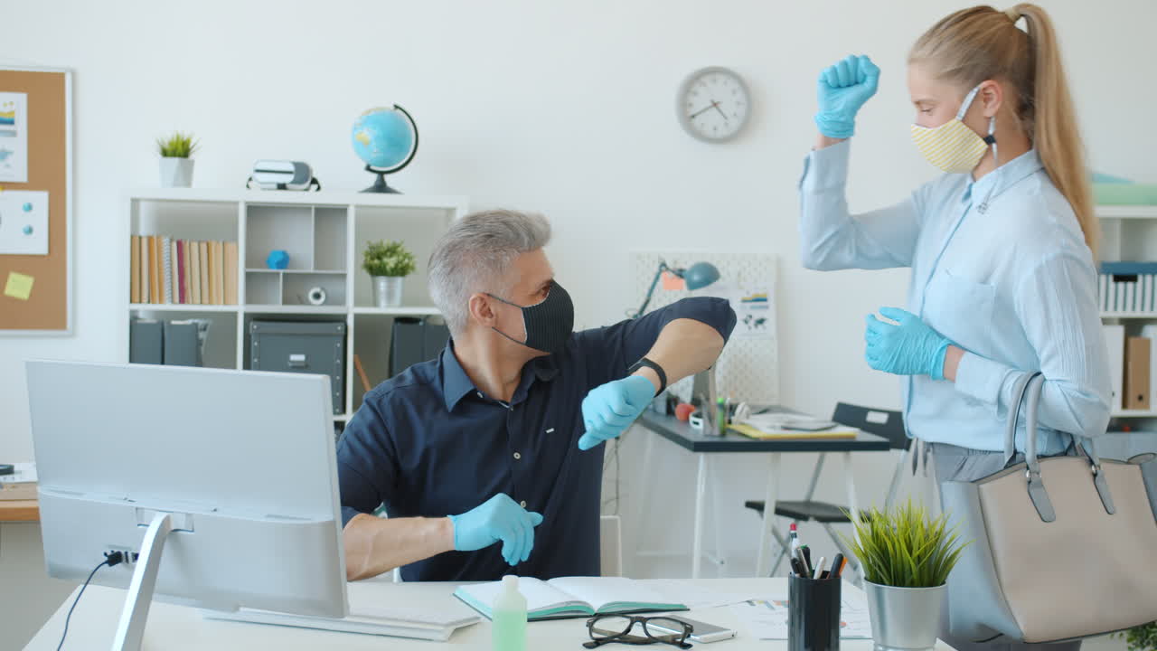 Employees working in office during pandemic wearing masks and gloves