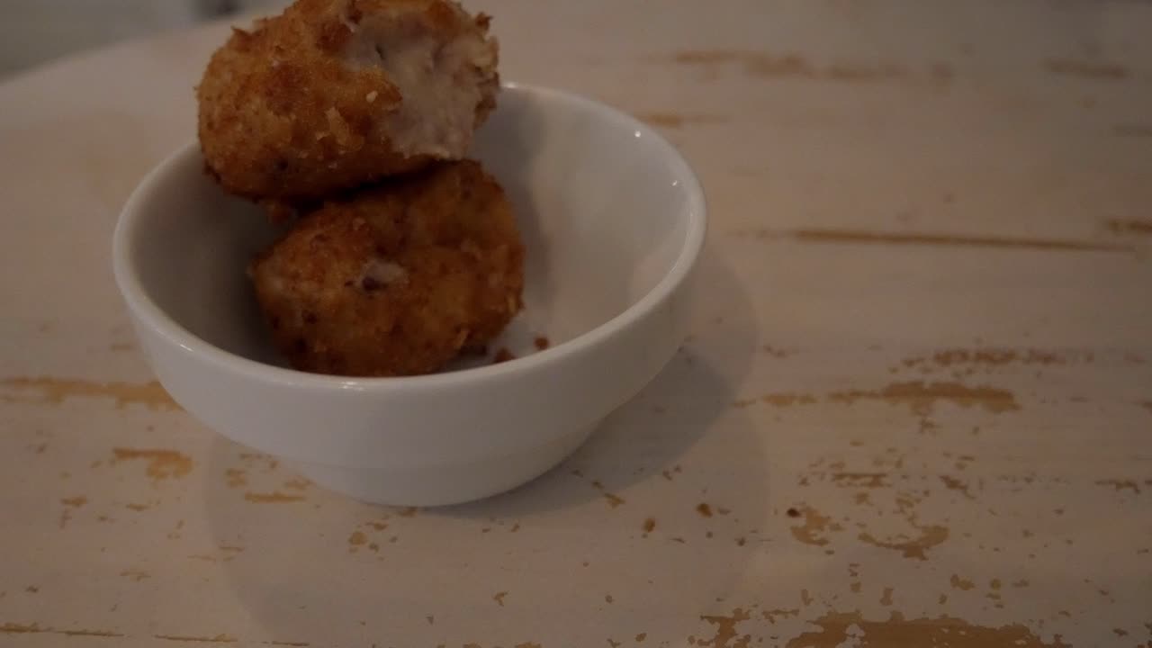 Deliziose crocchette di prosciutto in una ciotola su un tavolo rustico, atmosfera accogliente e calda.