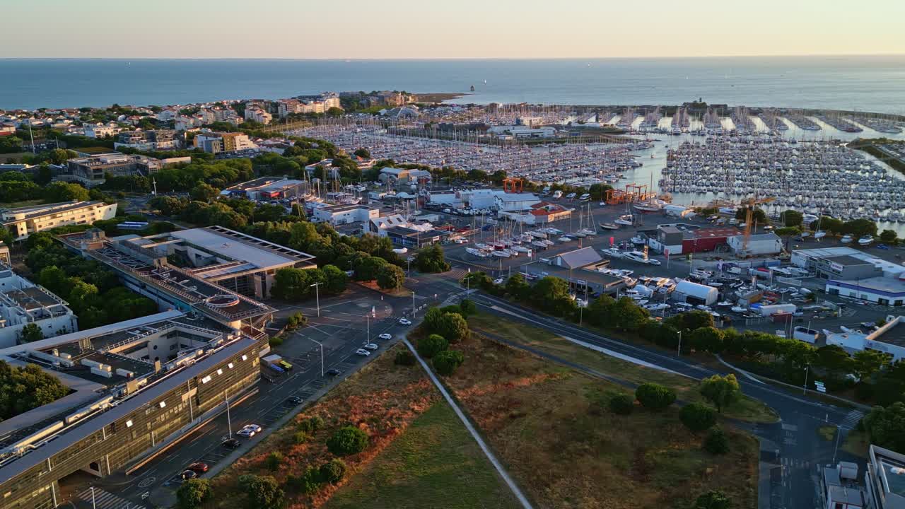 La Rochelle marina at golden hour, sailboats, city buildings, and Atlantic Ocean, France. Aerial drone panoramic view