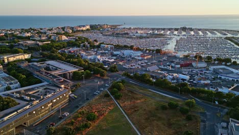 la rochelle marina at golden hour, sailboats, city buildings, and atlantic ocean, france. aerial drone panoramic view
