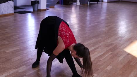 young woman stretching and practicing dance moves in a dance studio