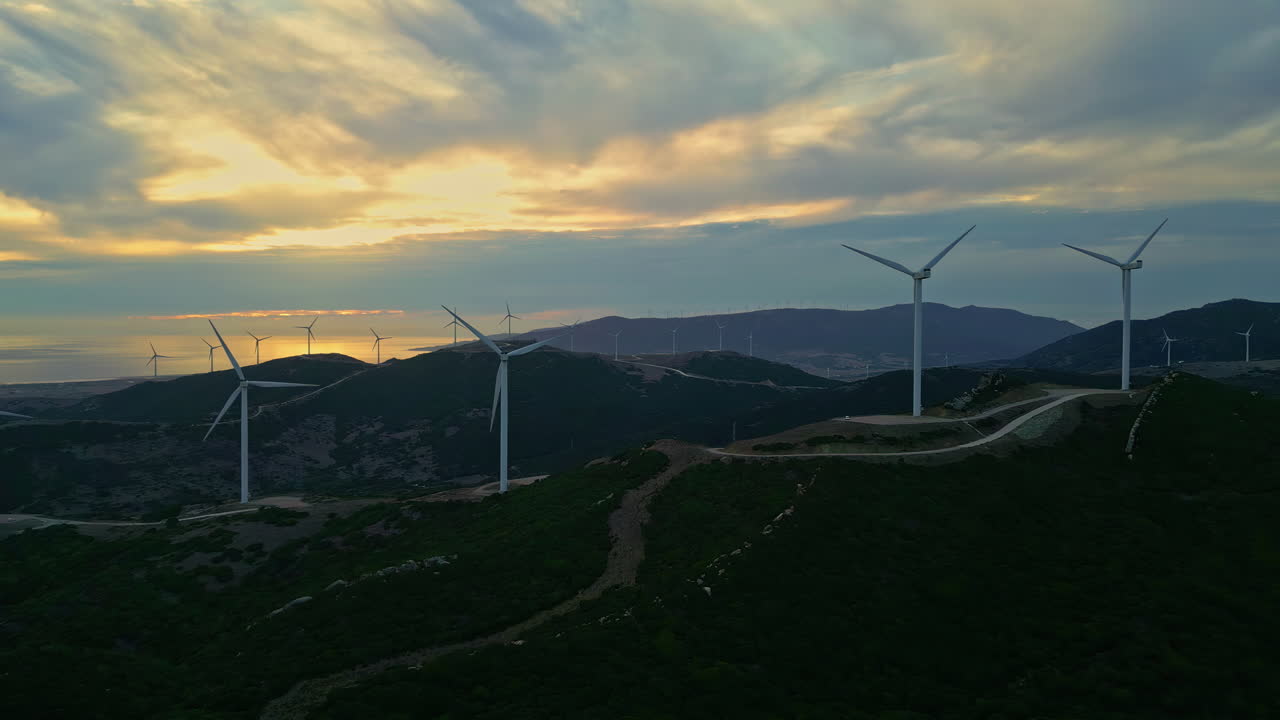 풍력 터빈과 구름진 하늘을 가진 숲과 산악 풍경 전망