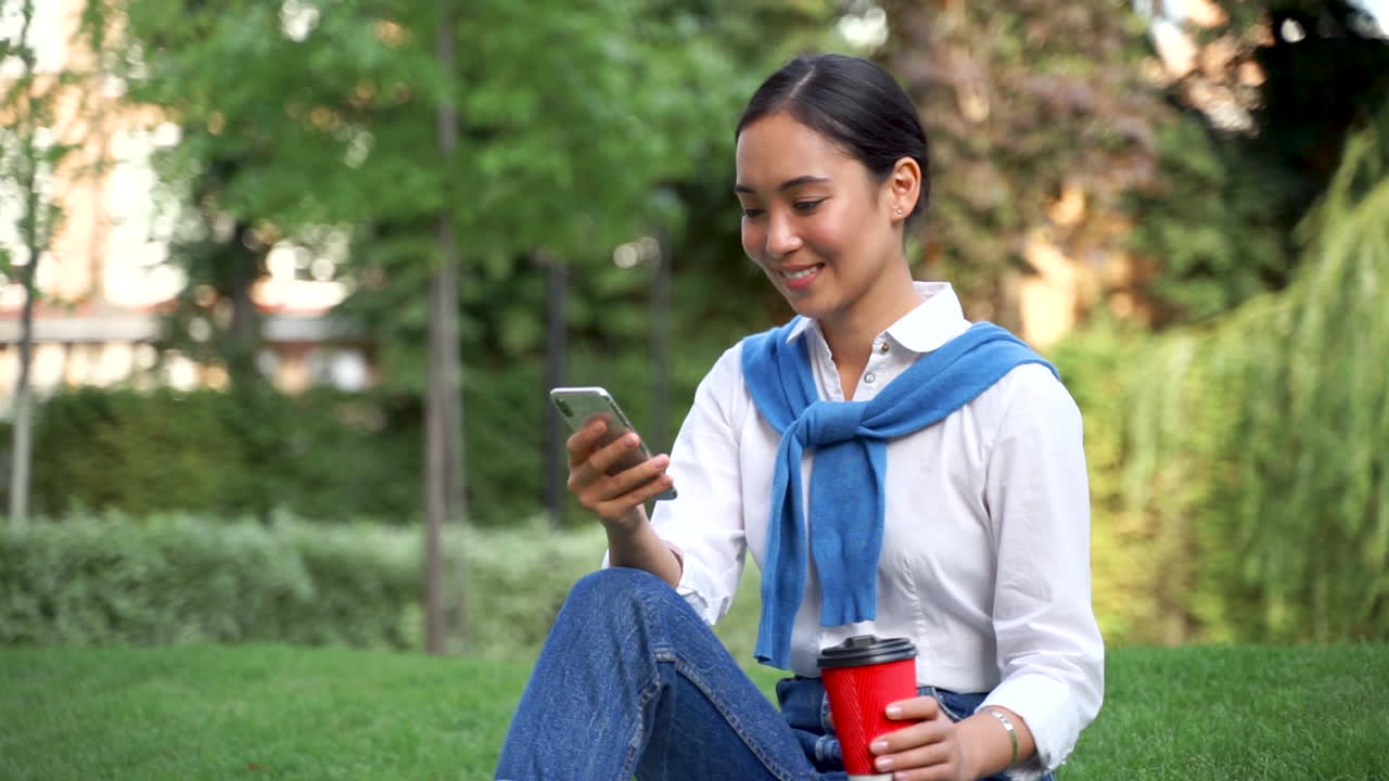 Donna che guarda lo smartphone e beve un caffè all'aperto