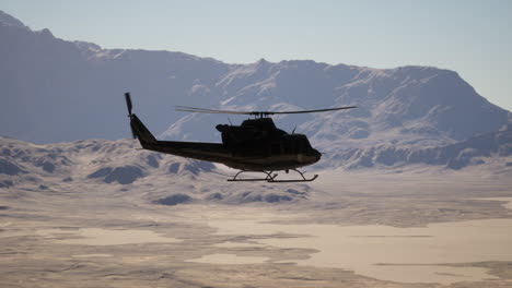 un helicóptero volando sobre una cordillera cubierta de nieve