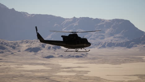 a helicopter flying over a snow covered mountain range