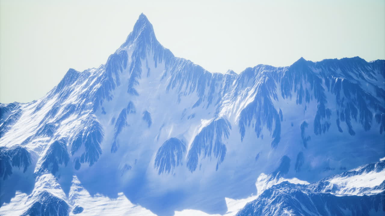 Majestic snow capped mountain peak rises against a clear blue sky