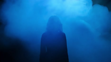 mysterious woman silhouette in blue smoke