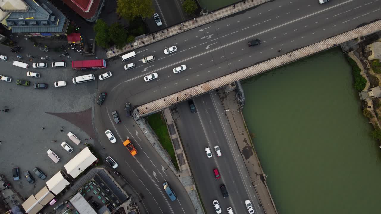 Aerial top of busy bridge and city traffic moving through central Tbilisi urban area
