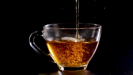 a sequence showing tea being poured into a clear glass cup against a dark backdrop, highlighting the liquid's motion and color