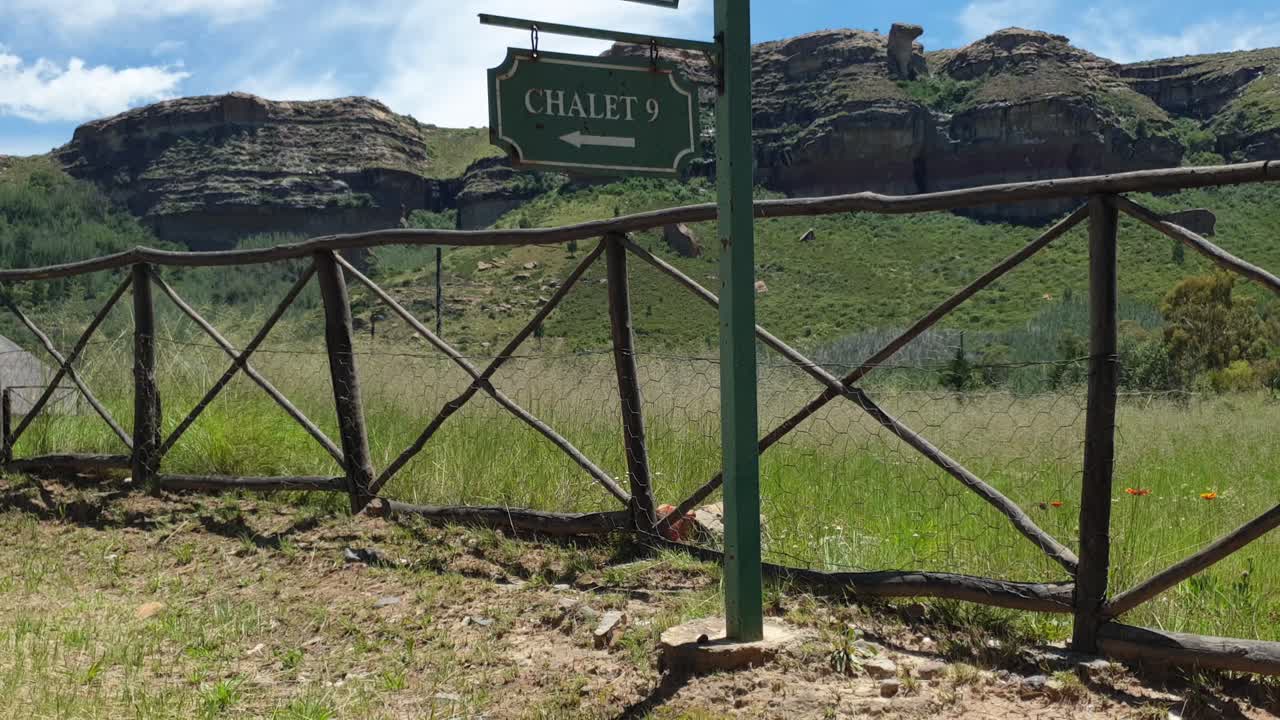 antiguo camino de ripio que conduce a los chalés y casas de huéspedes en la granja de vacaciones camelroc pasando por viejos árboles y vallas agrícolas, sudáfrica