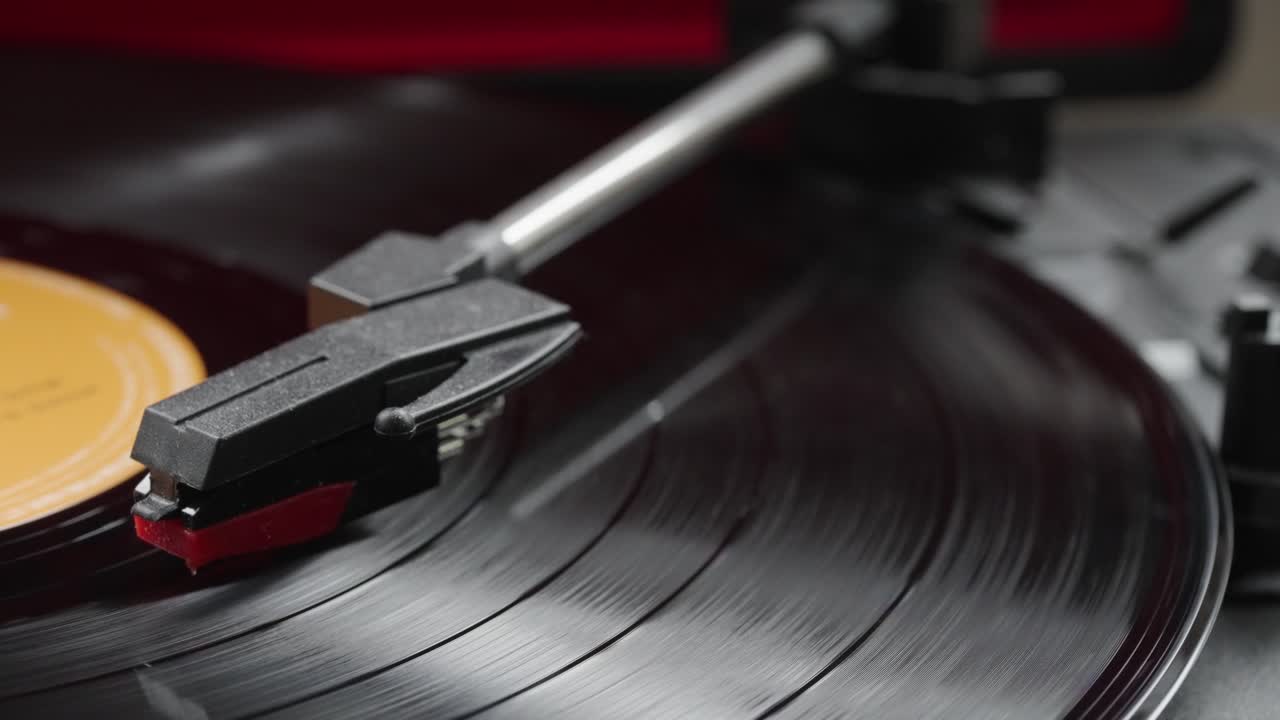 Close-up view of turntable arm over spinning on vintage record player with black vinyl