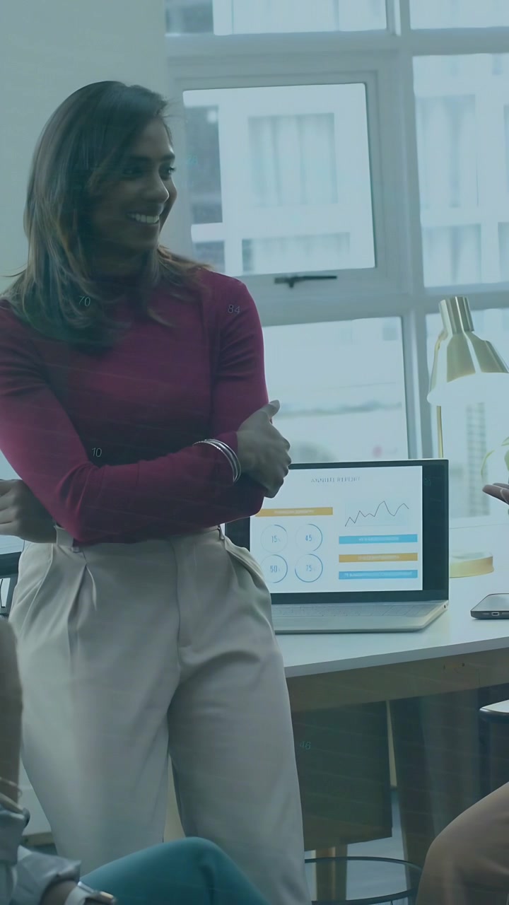 Vertical video: Standing woman listening business meeting team gesturing data lines showing charts