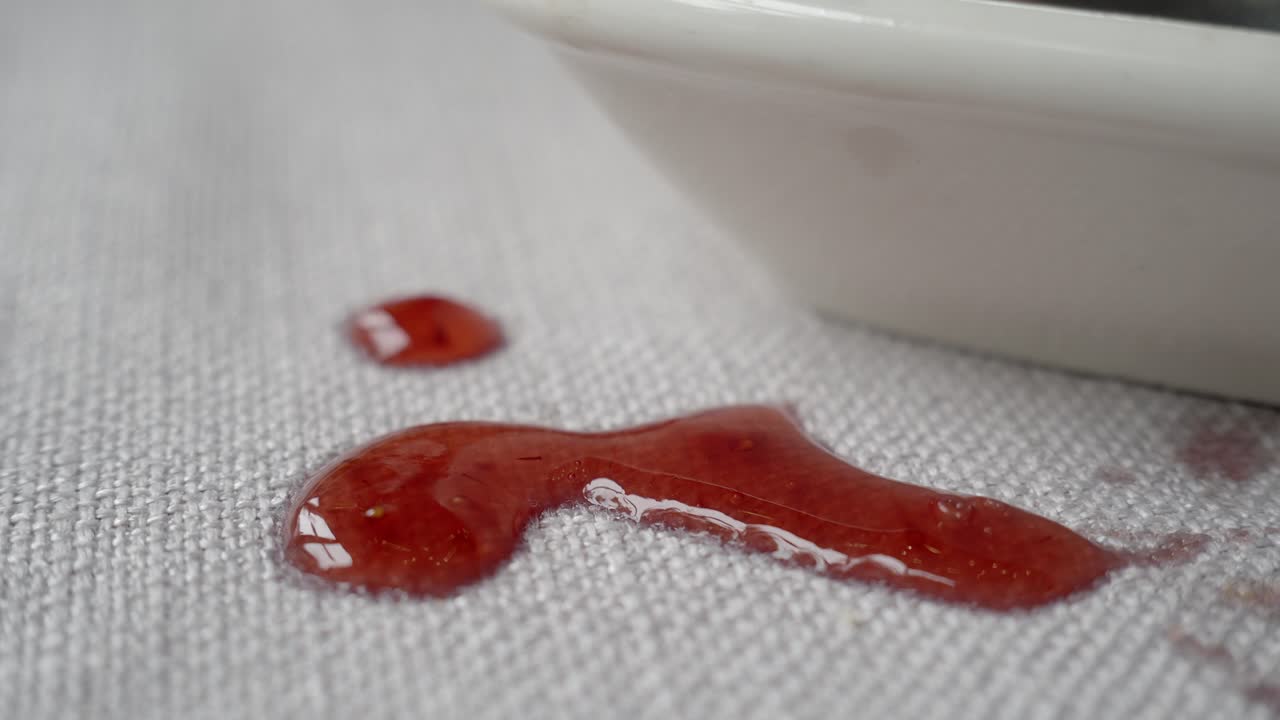 mermelada de fresa derramada en el mantel