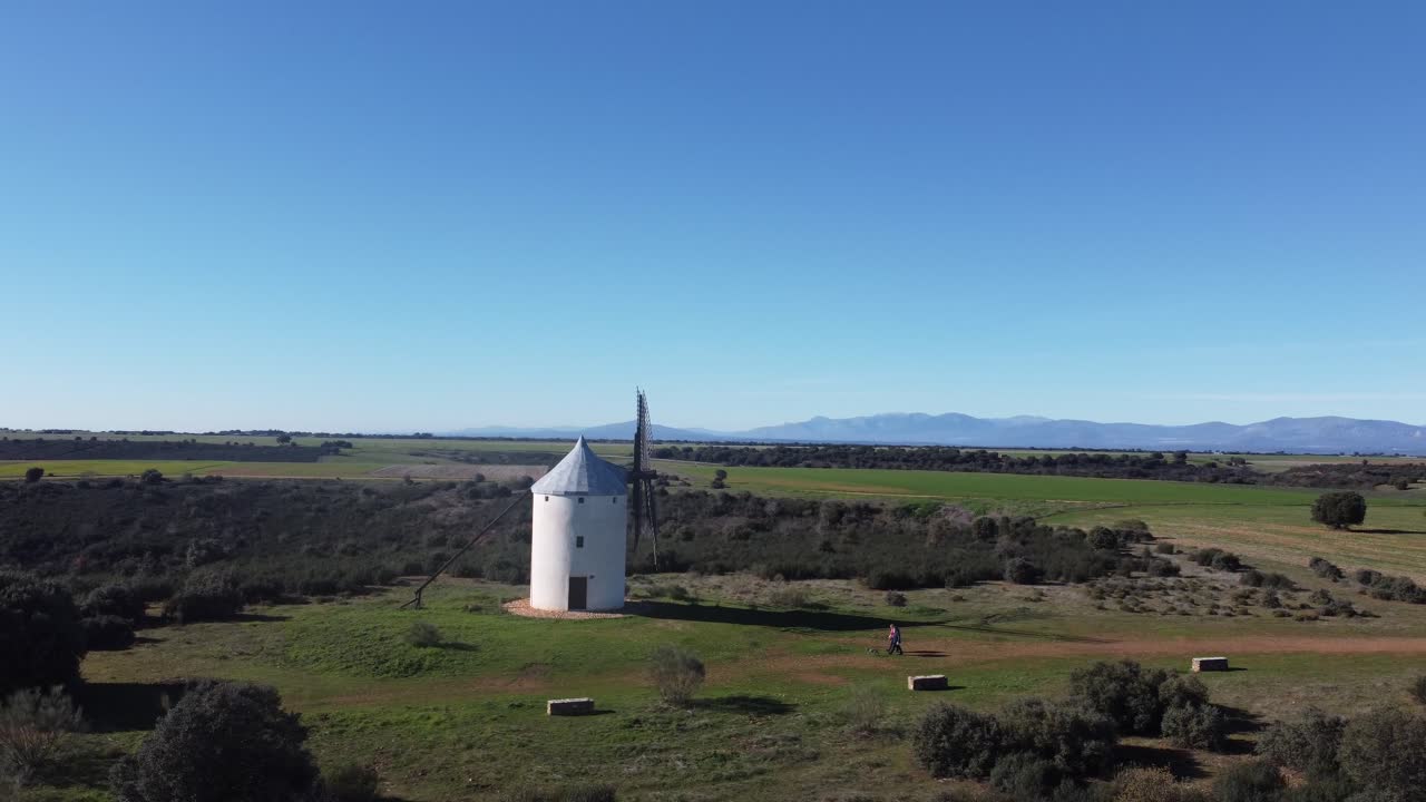 dos personas paseando un perro órbita escena aérea molino de viento tradicional