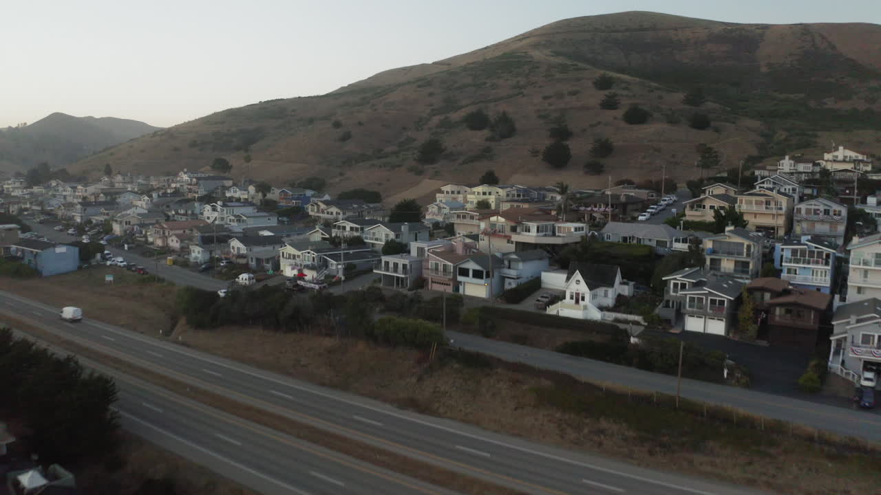 Aerial view of a hillside residential area with a highway running through it