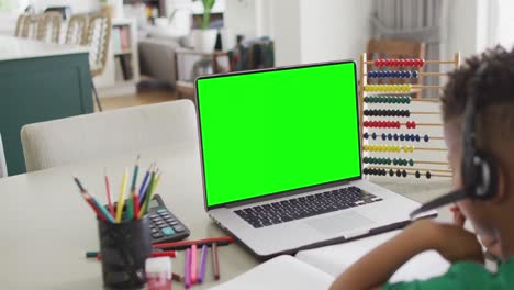 Composition-of-african-american-boy-on-laptop-online-learning-with-green-screen