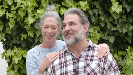 happy mature couple enjoying time together outdoors, smiling and embracing warmly