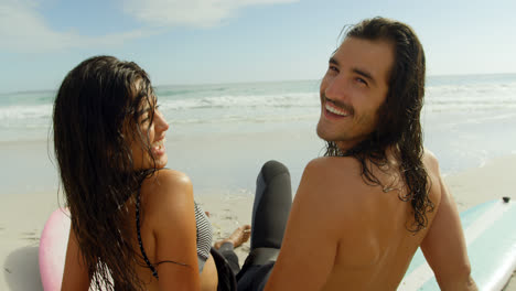 surfer couple sitting on the beach 4k 4k