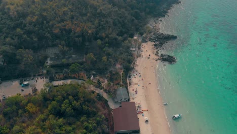 azure ocean waves roll on sand beach with people aerial view