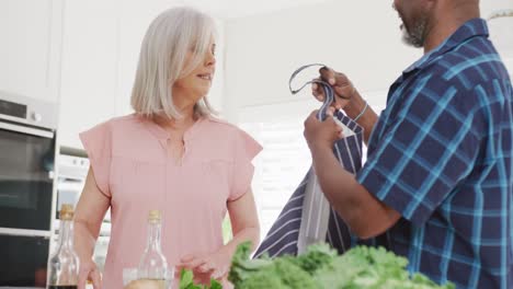 feliz pareja de alto nivel que usa delantales en la cocina