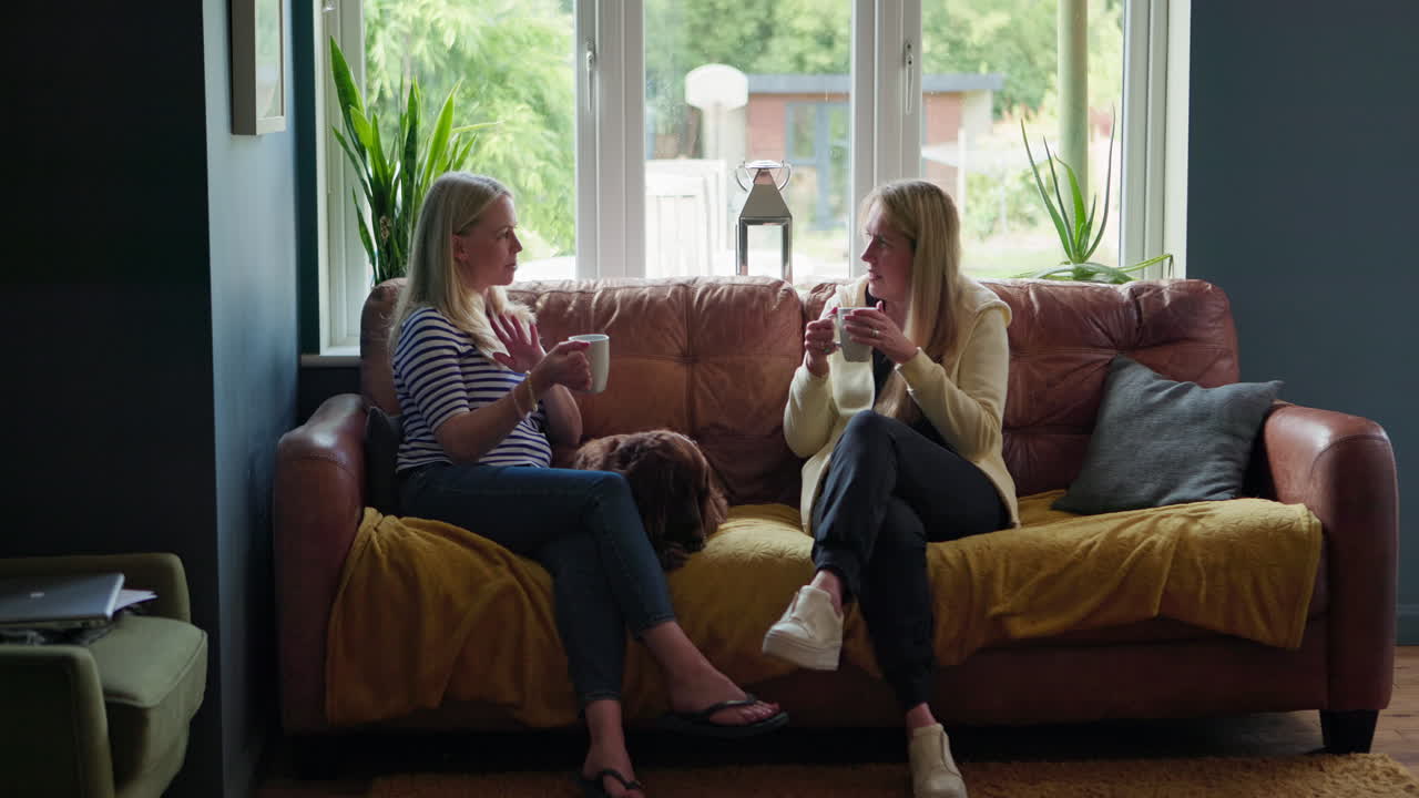 dos mujeres teniendo una conversación en un sofá