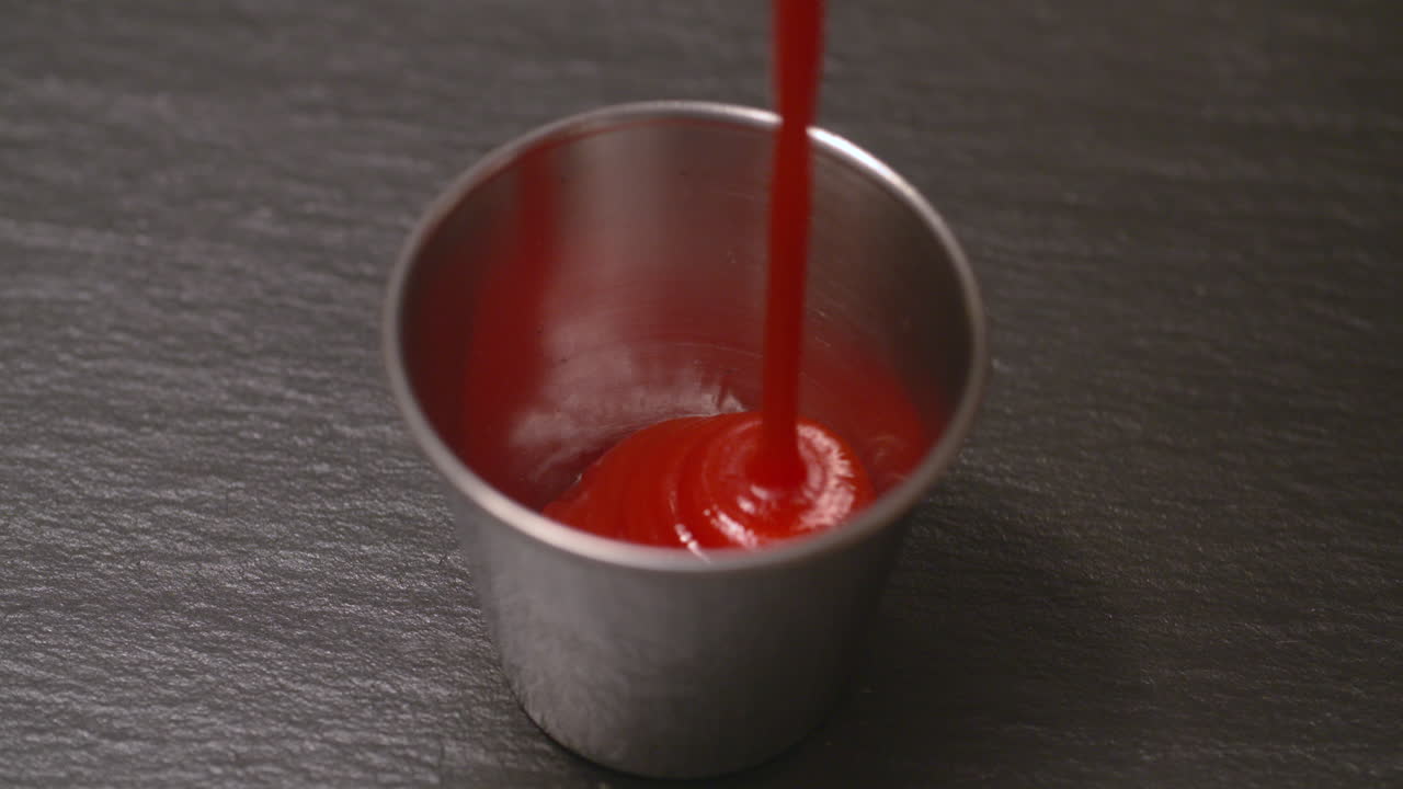 Squirting ketchup into a small dish