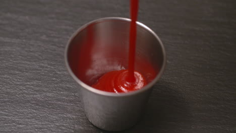 squirting ketchup into a small dish