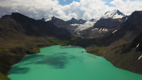 Aerial-drone-shot-of-the-Ala-Kol-lake-with-the-mountain-range-surrounding-it