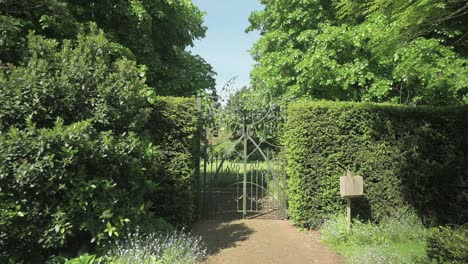 walking back from a metal gate dividing two different gardens