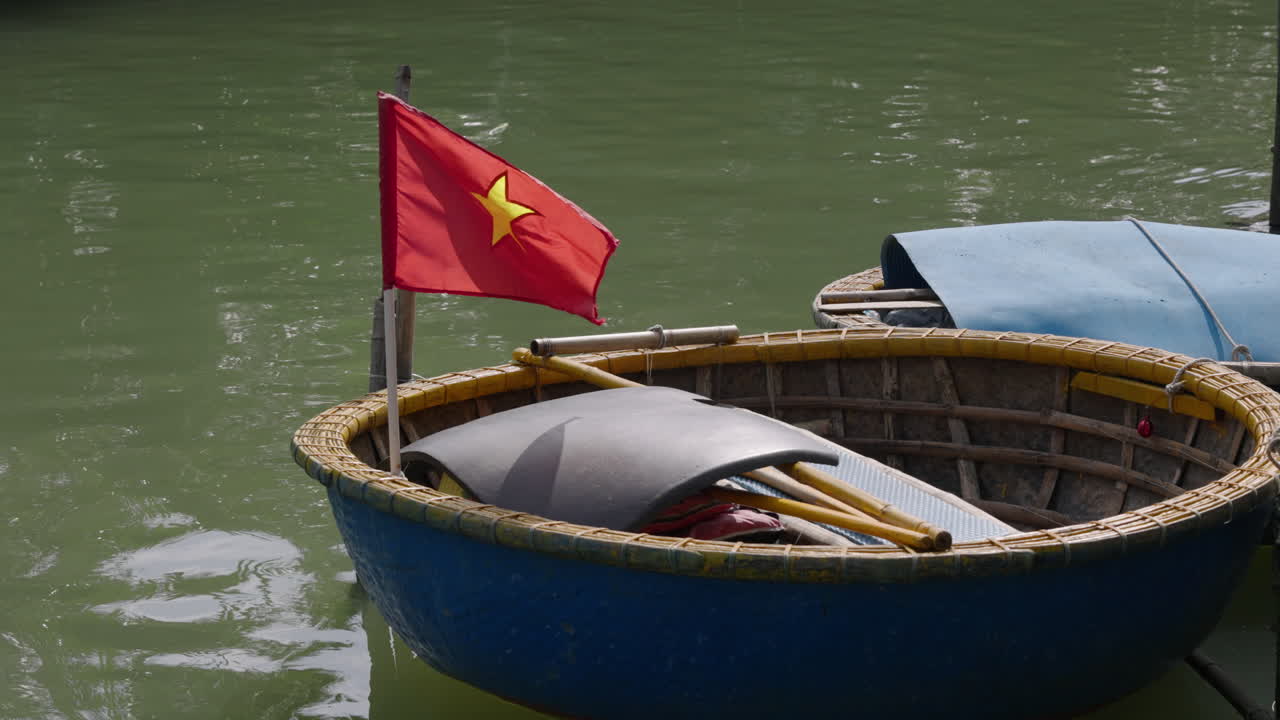 4K footage of tourists paddling traditional round coconut basket boats through palm‑lined canals in Vietnam