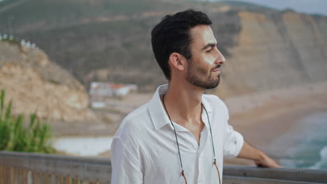 Peaceful-guy-enjoying-sea-closeup.-Man-going-stairway-looking-marine-landscape