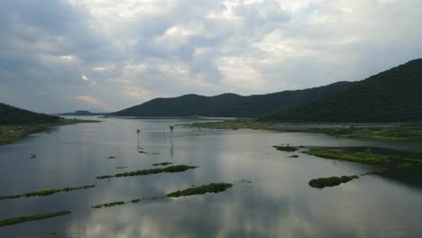 Sunset-at-he-lake-with-mountains-aerial-descending-footage-in-Muak-Klek,-Saraburi,-Thailand