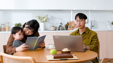 family working and reading together in kitchen