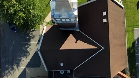 overhead top down aerial of church and steeple, roof contours and shadows during summer magic hour