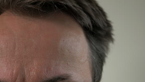 CLOSE-UP,-Man-Takes-Temperature-With-Digital-Thermometer-On-Forehead