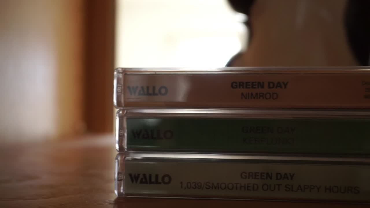 Wide Pan of Vintage Greenday Tapes - Cassettes on a shelf