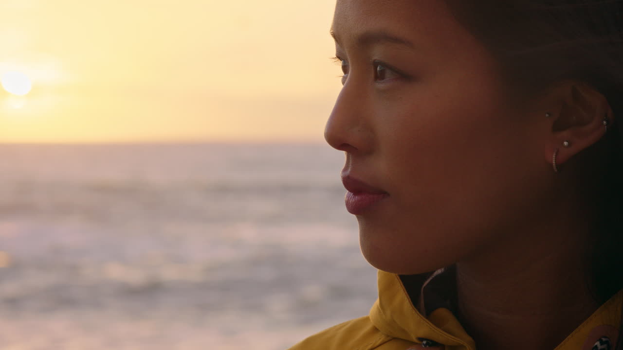 portrait d'une femme asiatique heureuse profitant d'une contemplation paisible explorant un style de vie insouciant se relaxant sur la plage se sentant positive au lever du soleil