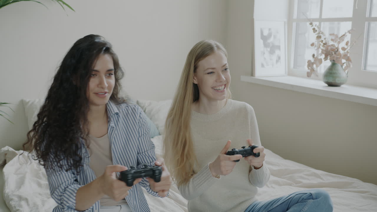 Two Women Playing Video Games in Bedroom