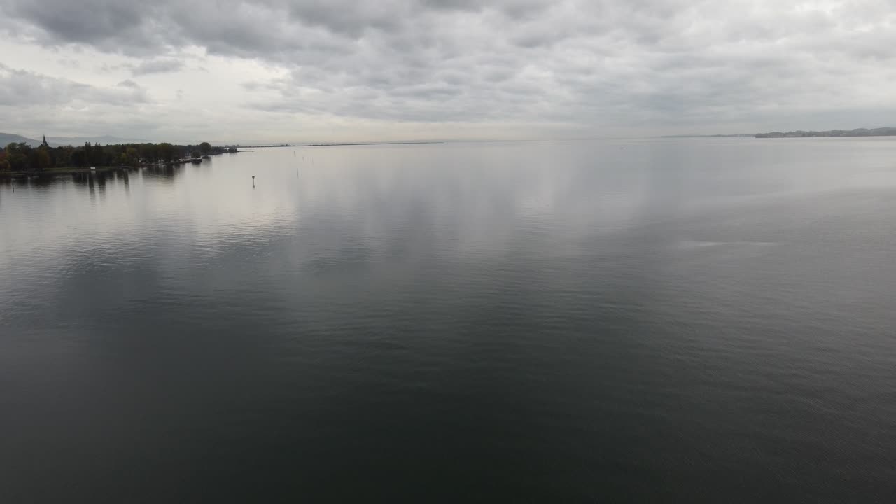 взгляд с воздуха на озеро констанс, счастливый облачный осенний день, на заднем плане небольшой лес на берегу, брегенц, форальберг, австрия, европа