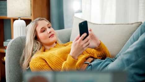 mujer relajándose en el sofá con el teléfono