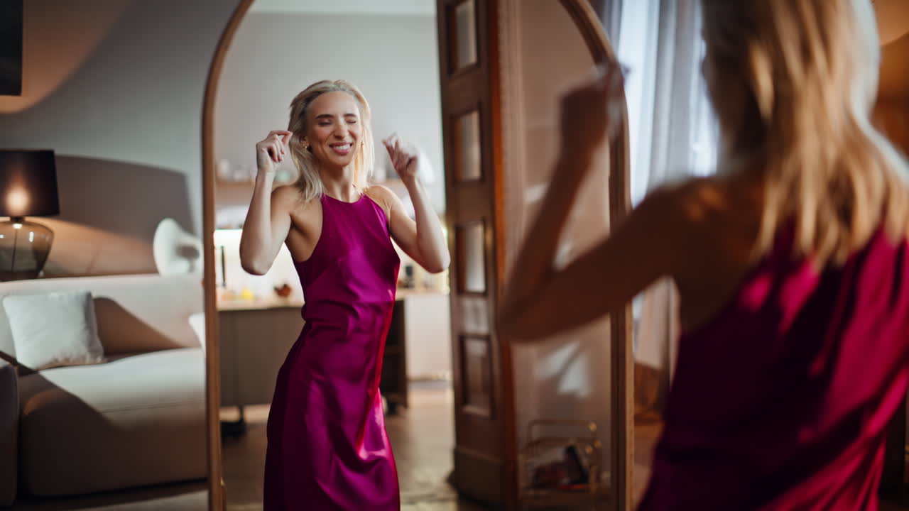 Joyful lady trying dress admiring stylish look in living room mirror closeup