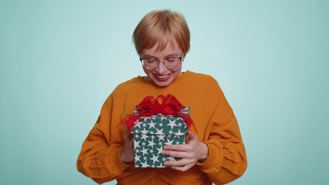 Woman opening gift box unwrapping birthday surprise great happiness amazement satisfied with present