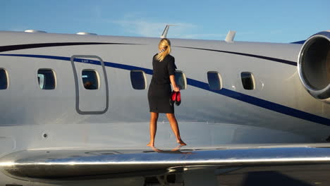 slomo: a playful flight attendant walks on the wing of an aircraft