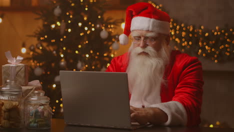 Alegre-Santa-Trabajando-En-Una-Computadora-Portátil.-Papá-Noel-Usando-El-Primer-Plano-De-La-Computadora-Portátil.-Imágenes-4k-De-Alta-Calidad