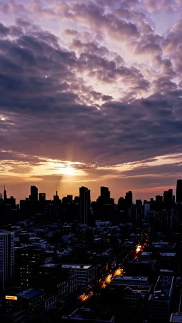 dramatic sunset over a silhouetted city skyline with traffic light trails